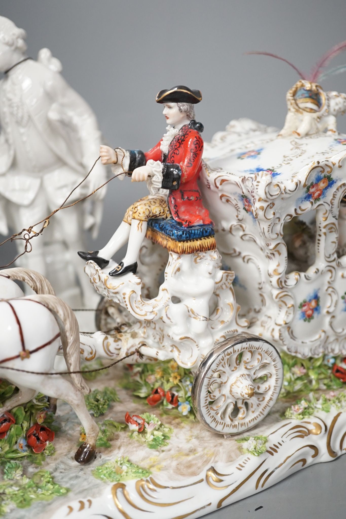 A large Italian porcelain carriage group and a pair of Italian white porcelain figure of a lady and a man 54cm